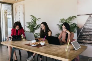 Stylish women working remotely in cafe
